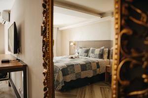 a bedroom with a bed and a mirror at Pousada Do Largo in Tiradentes