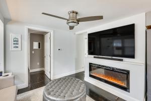 a living room with a fireplace and a tv at Modern Terryville Cottage with Deck and Lake View! in Terryville