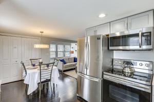 a kitchen with stainless steel appliances and a dining room at Modern Terryville Cottage with Deck and Lake View! in Terryville