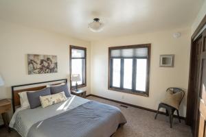 ein Schlafzimmer mit einem Bett, einem Fenster und einem Stuhl in der Unterkunft Grand View - Targhee Ski Resort, Jackson, Hot Tub in Tetonia