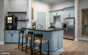 a kitchen with blue cabinets and a kitchen island with bar stools at Hidden Gem at Med Center 2BR & 2BA Apartment in Houston