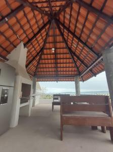 un banco en un pabellón con vistas al océano en Villas las Palmeras Casa Canaria 12 personas, en La Manzanilla