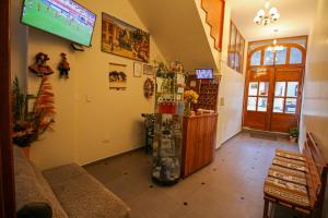 a living room with a tv on the wall at El Chasqui in Ollantaytambo