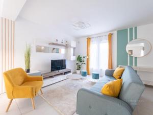 un salon avec un canapé bleu et un fauteuil jaune dans l'établissement Maison Moderne à 5 minutes des Jeux Olympiques Nautiques / entre Disney et Paris, à Saint-Thibault-des-Vignes