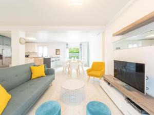 - un salon avec un canapé et une télévision dans l'établissement Maison Moderne à 5 minutes des Jeux Olympiques Nautiques / entre Disney et Paris, à Saint-Thibault-des-Vignes