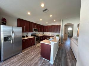 a kitchen with a stainless steel refrigerator and wooden cabinets at Welcome to LUX Guesthouse! in Ruskin