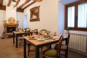 comedor con mesas y sillas y chimenea en Casa Rural Kabia, en Arráyoz