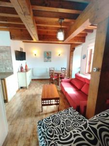 un salon avec un canapé rouge et une table dans l'établissement Apartamentos Copi Villa de Suances, à Suances