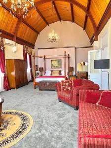 ein Wohnzimmer mit einem Bett und einem roten Sofa in der Unterkunft Abbey Boutique Hotel Adults only in Warwick