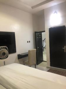 a bedroom with a bed and a desk and a chair at DAVIZZ HOTEL AND SUITES in Asaba