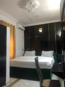 a bedroom with a bed and a chair in it at DAVIZZ HOTEL AND SUITES in Asaba