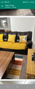 a black couch with yellow pillows in a living room at Northampton town in Kingsthorpe