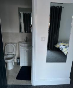 a bathroom with a toilet and a sink and a mirror at Northampton town in Kingsthorpe