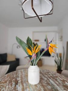 eine weiße Vase mit Blumen auf einem Tisch in der Unterkunft Excelente Departamento en Av. Del Libertador in Buenos Aires