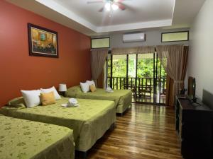 a hotel room with two beds and a balcony at Hotel El Bambu in Sarapiquí