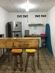 a kitchen with a wooden table and two stools at rooms megi terminal in Cahuita