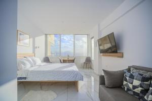 a bedroom with a bed and a tv and a couch at Ble Property Atlas in Loutraki