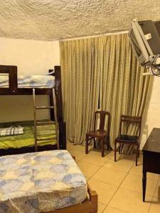 a bedroom with two bunk beds and a table and chairs at Villa Esperanza - Casa de verano in Cieneguilla