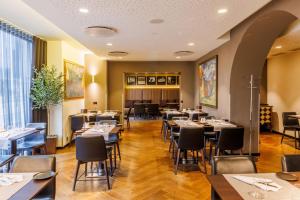 - un restaurant avec des tables et des chaises dans une salle dans l'établissement Palace Hotel Tallinn, a member of Radisson Individuals, à Tallinn