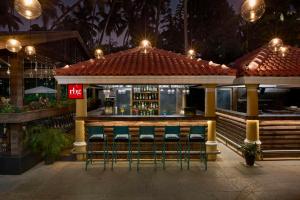 a bar with green stools in front of it at Park Inn by Radisson Goa Candolim in Candolim