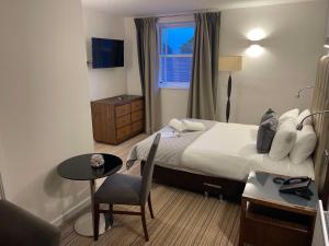 een slaapkamer met een bed, een tafel en een stoel bij The George - Sure Hotel Collection by Best Western in Darlington