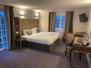 The George - Sure Hotel Collection by Best Western في دارلينغتون: غرفة فندقية بسرير كبير وكرسي