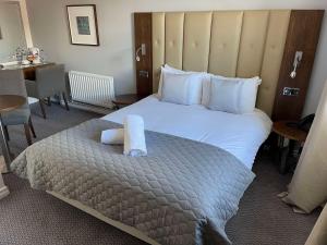 a hotel room with a bed with a roll on it at The George - Sure Hotel Collection by Best Western in Darlington