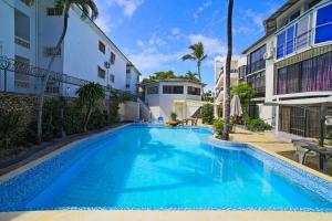 a large blue swimming pool next to a building at Studio Apartment Center of Sosua Remote Worker Space Fast WiFi in Sosúa