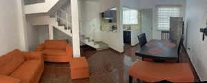 ein Wohnzimmer mit einem Tisch, Stühlen und einer Treppe in der Unterkunft Apartamentos Tampico-Altamira 