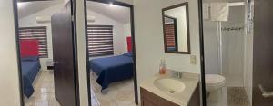 uma casa de banho com um lavatório, um WC e uma cama em Apartamentos Tampico-Altamira 