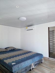 a bedroom with a bed in a white room at RICAURTE CASA PISCINA PRIVADA in Ricaurte
