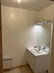 a white bathroom with a sink and a mirror at Studio à 2 pas du métro in Clichy