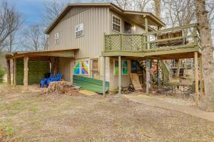 a house with a balcony and a tree at Cozy Riverfront Cabin about 2 Mi to Main Street Hardy in Hardy