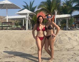 Dos mujeres en bikini de pie en la playa en Sand Castle Ocean Suites, en Zorritos