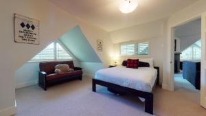 a bedroom with a bed and a chair with a teddy bear at Stylish Home with Mountain Views by Harmony Whistler in Whistler