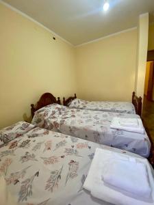 two beds in a small room with a bedspread with towels at Las Maravillas del Talampaya II in Villa Unión