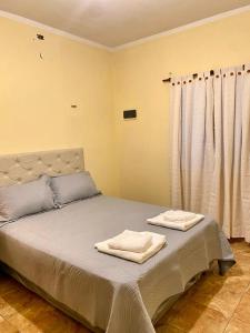 a bedroom with a bed with two towels on it at Las Maravillas del Talampaya II in Villa Unión