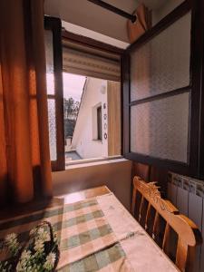 ein Esszimmer mit einem Tisch und einem Fenster in der Unterkunft AL Vila Lina in São Pedro do Sul