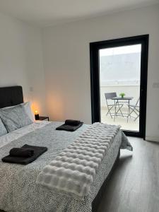 een slaapkamer met een bed en uitzicht op een patio bij CASA FLIPE t2 in Bragança