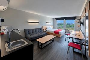 a room with a couch and a bed and a kitchen at City Express by Marriott Tijuana Rio in Tijuana