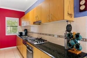 a kitchen with wooden cabinets and a stove top oven at Welcome to your Surf Beach Getaway in Kiama