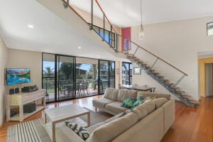a living room with a couch and a staircase at Aaronvale in Point Lookout