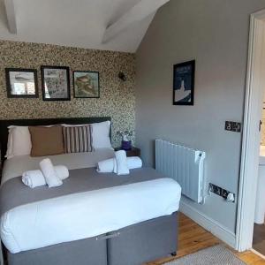 a bedroom with a large bed with white pillows at The Three Swallows Cley in Cley next the Sea