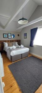 a bedroom with two beds and a rug at The Three Swallows Cley in Cley next the Sea