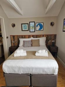 a bedroom with a large bed with two towels at The Three Swallows Cley in Cley next the Sea