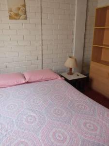 sypialnia z łóżkiem i stołem z lampką w obiekcie Beach House SantaElena w mieście Pisco