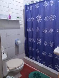 a blue shower curtain in a bathroom with a toilet at Beach House SantaElena in Pisco