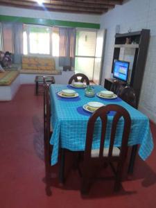 uma mesa de jantar com uma toalha de mesa azul e cadeiras em Beach House SantaElena em Pisco