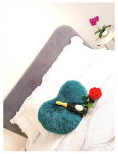 ein grüner Handschuh auf einem Bett mit einer Rose in der Unterkunft Chic in Fiumicino