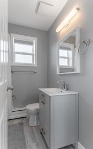 y baño con aseo, lavabo y espejo. en Modern Downtown 3BR 2B Home, en Yellowknife